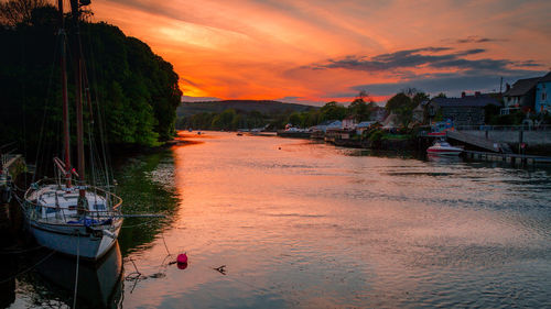 Boats moored at harbor during sunset