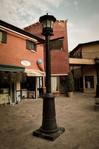 Street light by building against sky