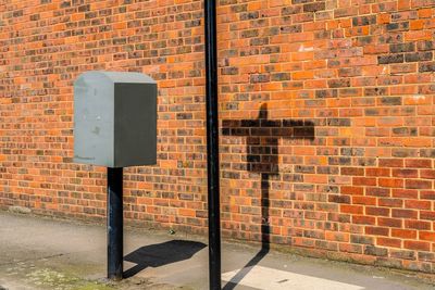 Shadow on brick wall by footpath