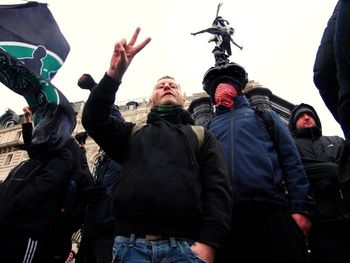 Low angle view of people standing against clear sky