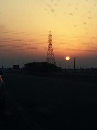 Silhouette of electricity pylon at sunset