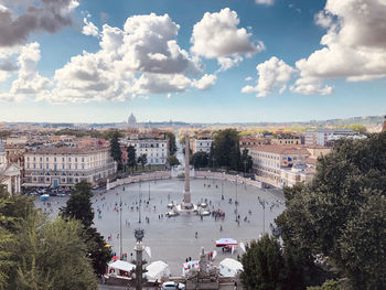 High angle view of city buildings against cloudy sky