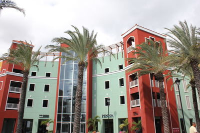 Low angle view of palm trees and building against sky