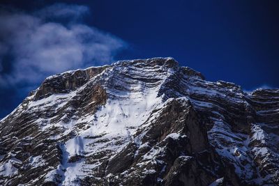 Snow covered mountain against blue sky