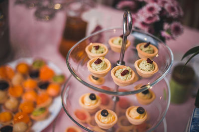 High angle view of small pastries on table on a glass cake stand