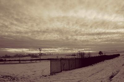 Scenic view of beach against cloudy sky