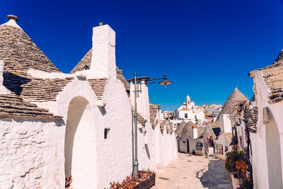 Buildings in city against clear blue sky