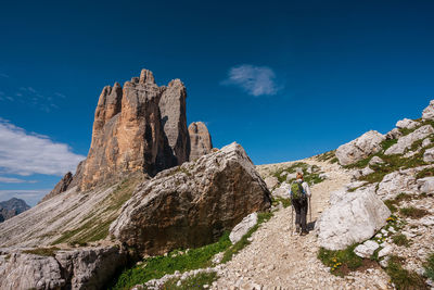 Rear view of woman walking on rock against sky