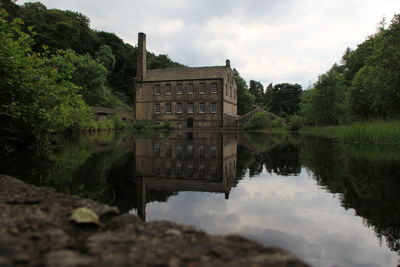 Reflection of building in lake against sky