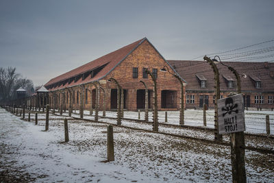 Built structure on snow covered field against sky