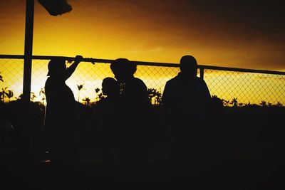 Silhouette men with people in background at night