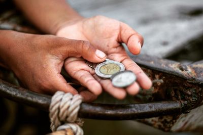 Close-up of hand holding coins