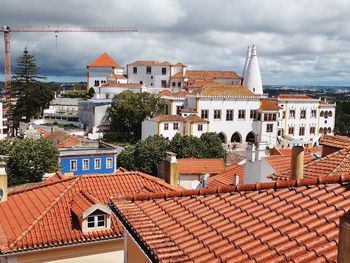 Houses in town against cloudy sky