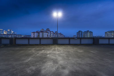 Illuminated pier by sea against sky at night