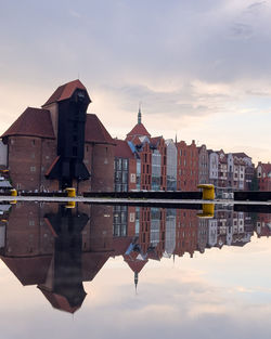 Reflection of buildings in lake against sky