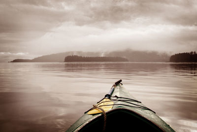 Boat moored on lake against sky