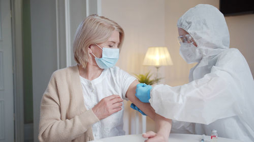 Portrait of female dentist examining patient at home