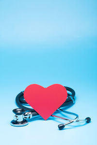 Close-up of heart shape on table against blue background