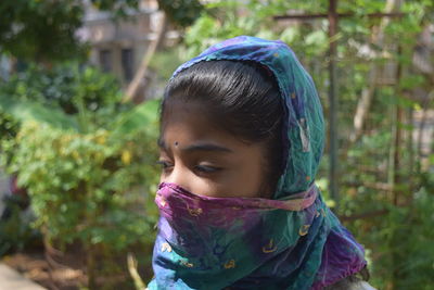 Close-up of girl covering face with scarf
