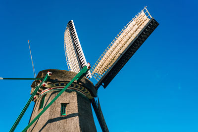 Low angle view of traditional windmill against clear blue sky