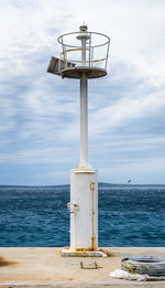 Lifeguard hut by sea against sky