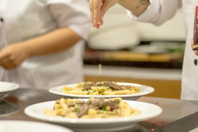Midsection of woman having food in restaurant