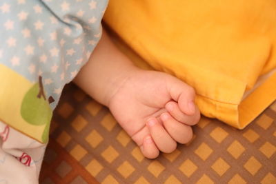 Low section of baby feet on bed at home