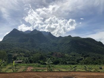 Scenic view of land and mountains against sky