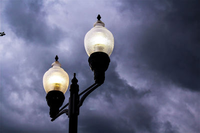 Low angle view of illuminated street light against sky