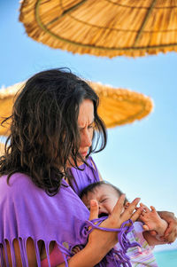 Low angle view of mother and daughter against clear sky