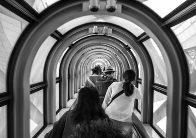 Rear view of people walking in tunnel