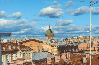 Buildings in city against cloudy sky