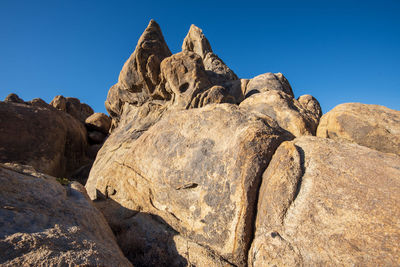 Low angle view of rocks against blue sky