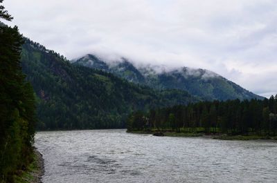 Scenic view of lake by mountains against sky