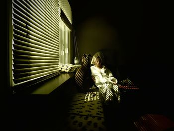 Portrait of woman wearing bathrobe while sitting at home