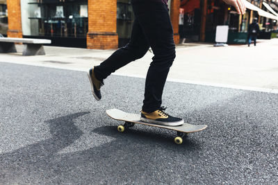 Young skateboarder on the street, partial view