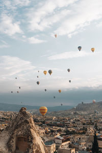 Hot air balloons flying over buildings in city