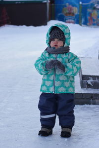 Portrait of boy standing in snow
