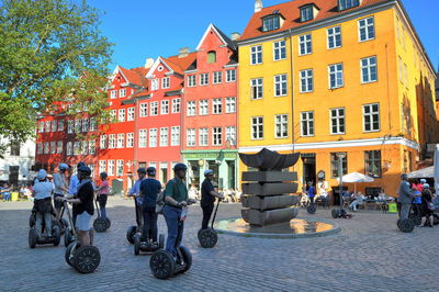 People on street against buildings in city