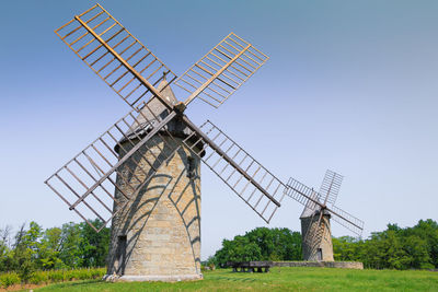 Traditional windmill on field against clear sky