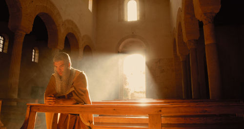 Young viking man prays in a large church