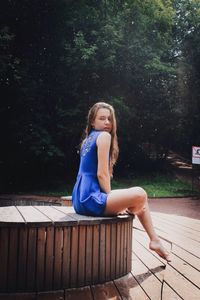 Portrait of girl sitting against tree