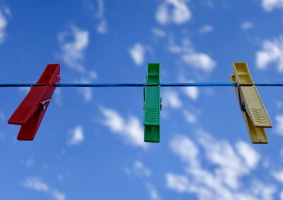 Low angle view of flags hanging against blue sky