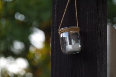 Close-up of light bulb on wooden post