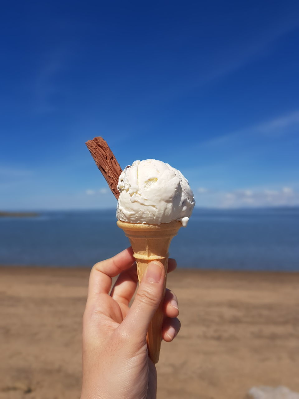 hand, ice cream cone, ice cream, food and drink, frozen food, sweet food, sweet, frozen, food, holding, one person, dairy, cone, dessert, blue, adult, close-up, day, temptation, nature, freshness, outdoors
