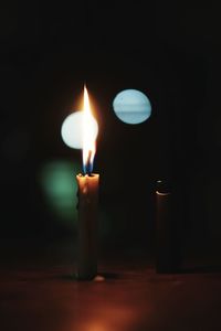 Close-up of lit candle in darkroom