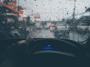 Person driving car in city during rainy season