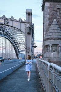 Rear view of woman on bridge against sky