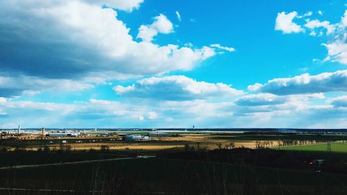 Scenic view of field against cloudy sky