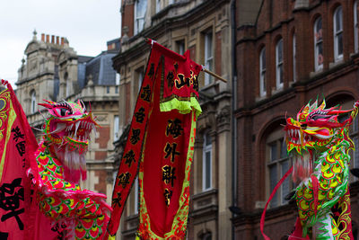 Low angle view of text and dragons against buildings during chinese new year